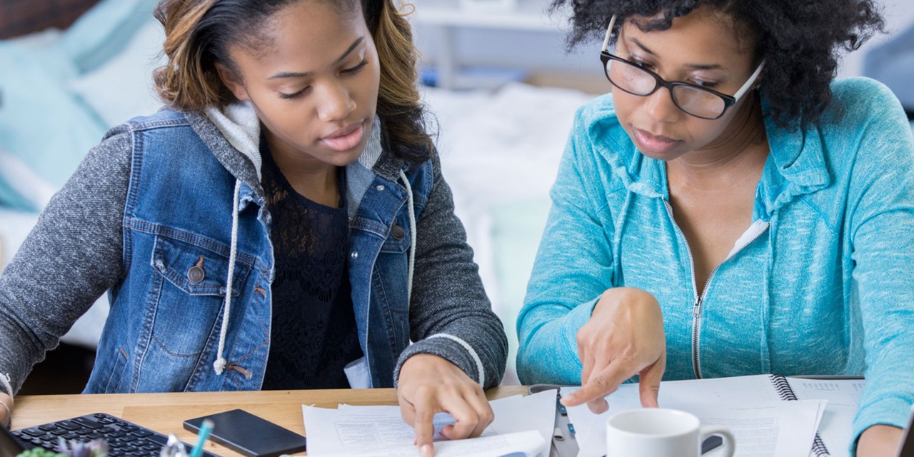 Mother helping daughter with financial education